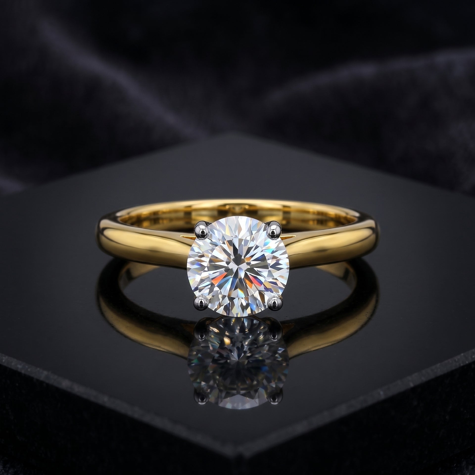 Gold ring with a large diamond on a black reflective surface