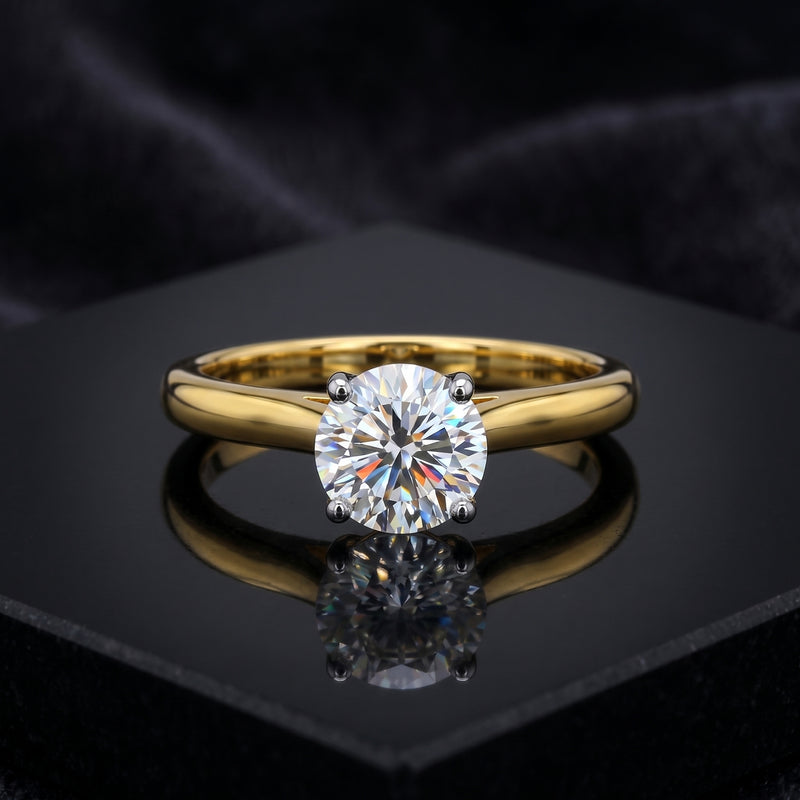 Gold ring with a large diamond on a black reflective surface