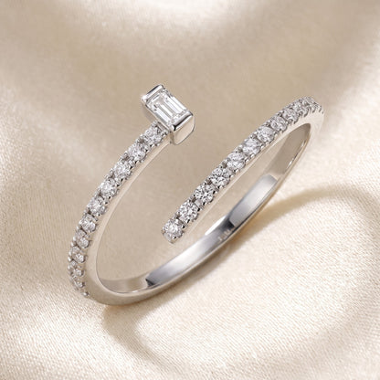 Silver ring with diamond accents on a beige background