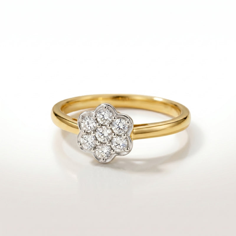 Gold ring with a diamond flower-shaped center on a white background