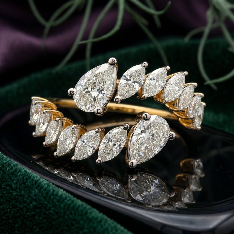 Open wrap-style gold ring featuring marquise and pear-shaped lab-grown diamonds on a natural background.