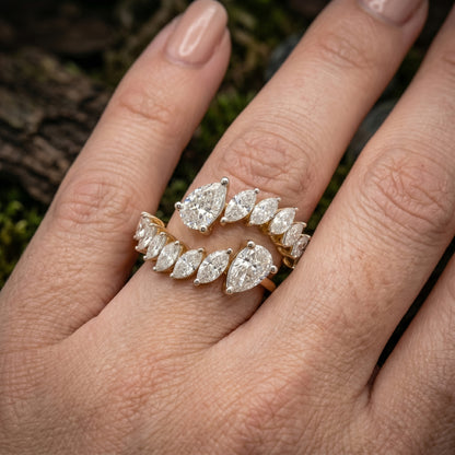 Open wrap-style gold ring featuring marquise and pear-shaped lab-grown diamonds worn on a hand in a close-up lifestyle shot.