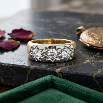 Elegant gold ring with a sparkling lab-grown diamond displayed on a marble surface with decorative accents.