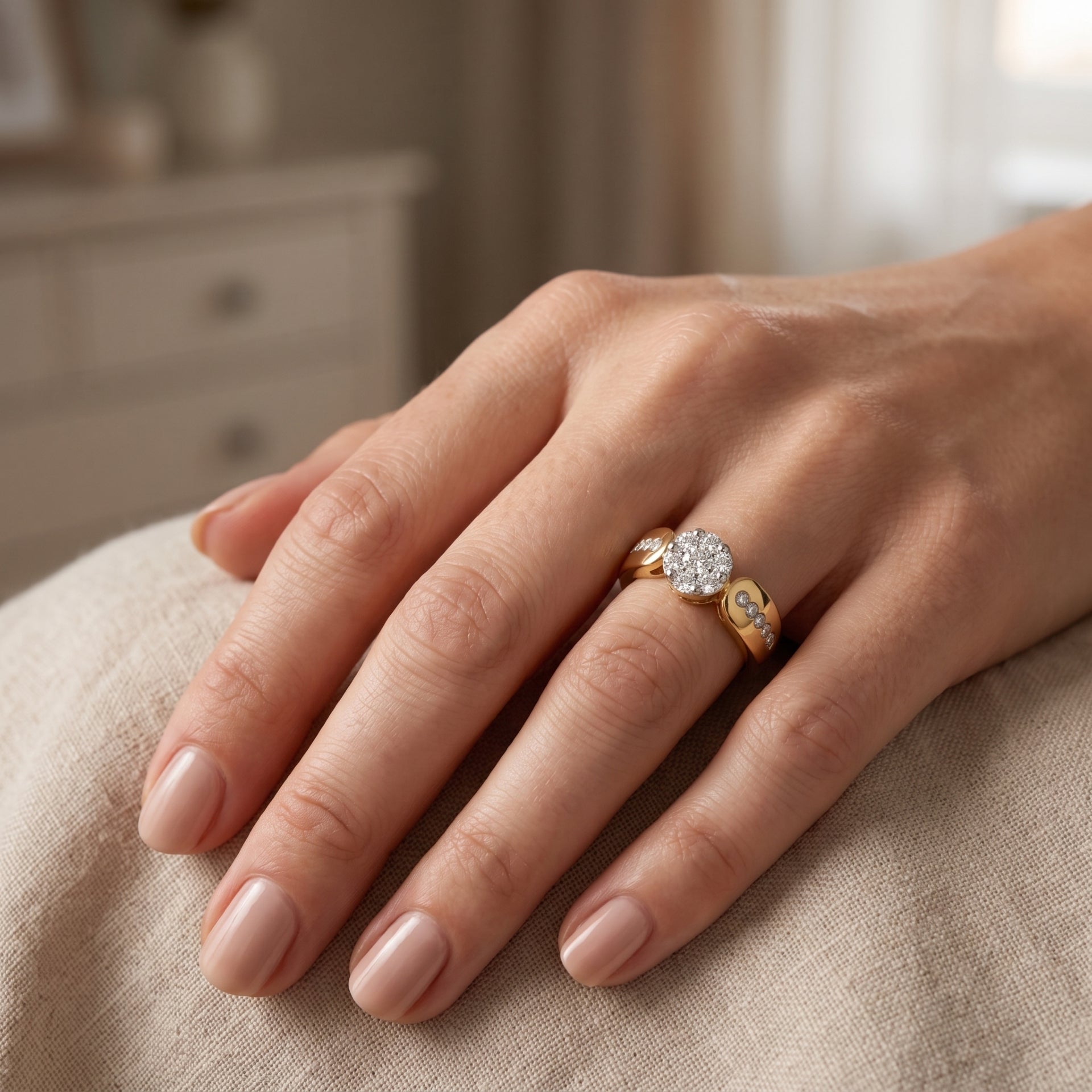Hand wearing a diamond ring on a neutral background