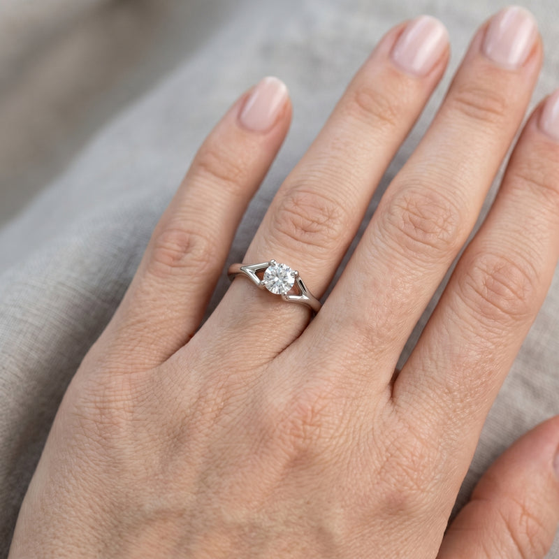 Hand wearing an elegant solitaire lab-grown diamond ring in a lifestyle close-up.