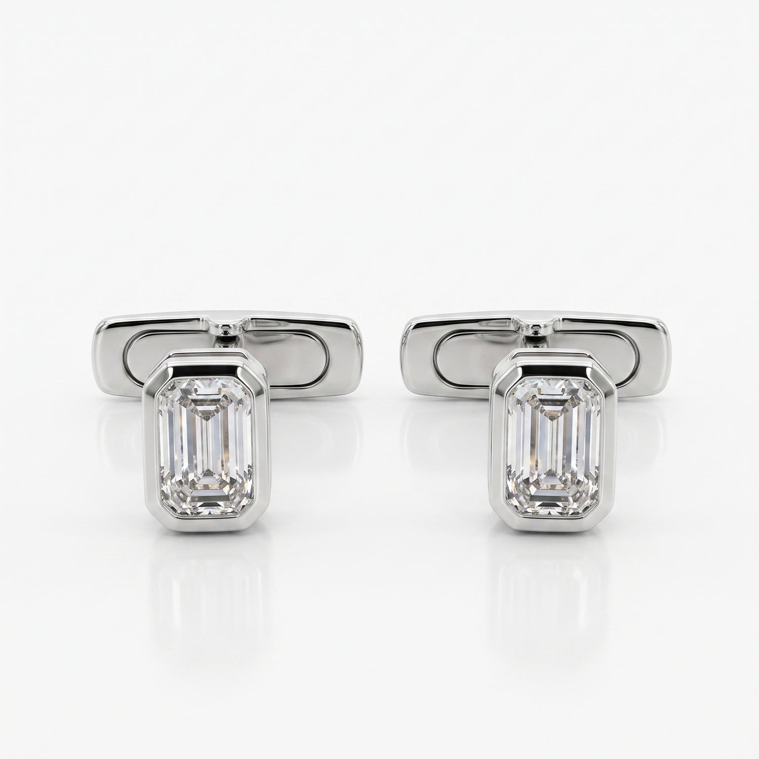 A pair of silver-toned cufflinks, each featuring an emerald-cut clear gemstone in a polished rectangular setting, displayed on a clean white reflective surface.