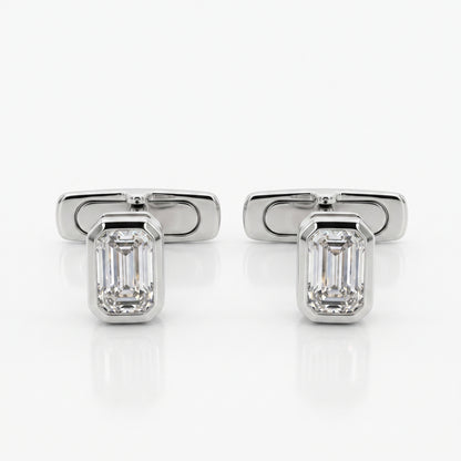 A pair of silver-toned cufflinks, each featuring an emerald-cut clear gemstone in a polished rectangular setting, displayed on a clean white reflective surface.