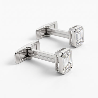A pair of silver-toned cufflinks with rectangular emerald-cut clear gemstones, displayed on a clean white background.