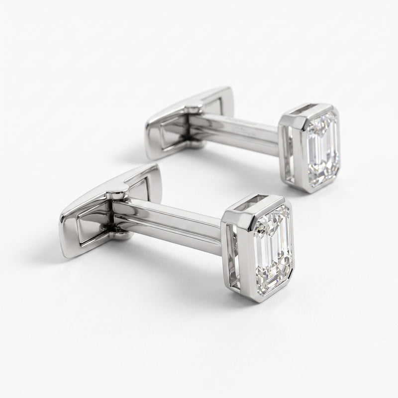A pair of silver-toned cufflinks with rectangular emerald-cut clear gemstones, displayed on a clean white background.
