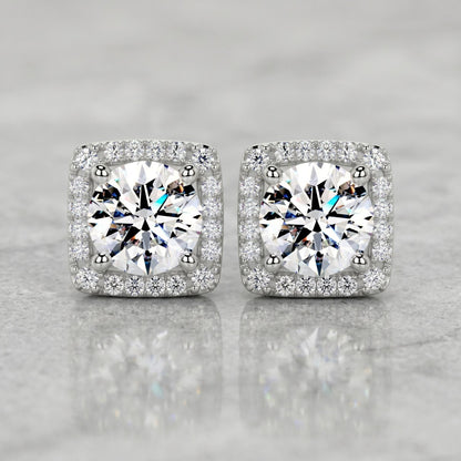 Square halo stud earrings featuring brilliant round lab-grown diamonds surrounded by a sparkling diamond halo on a polished marble surface.