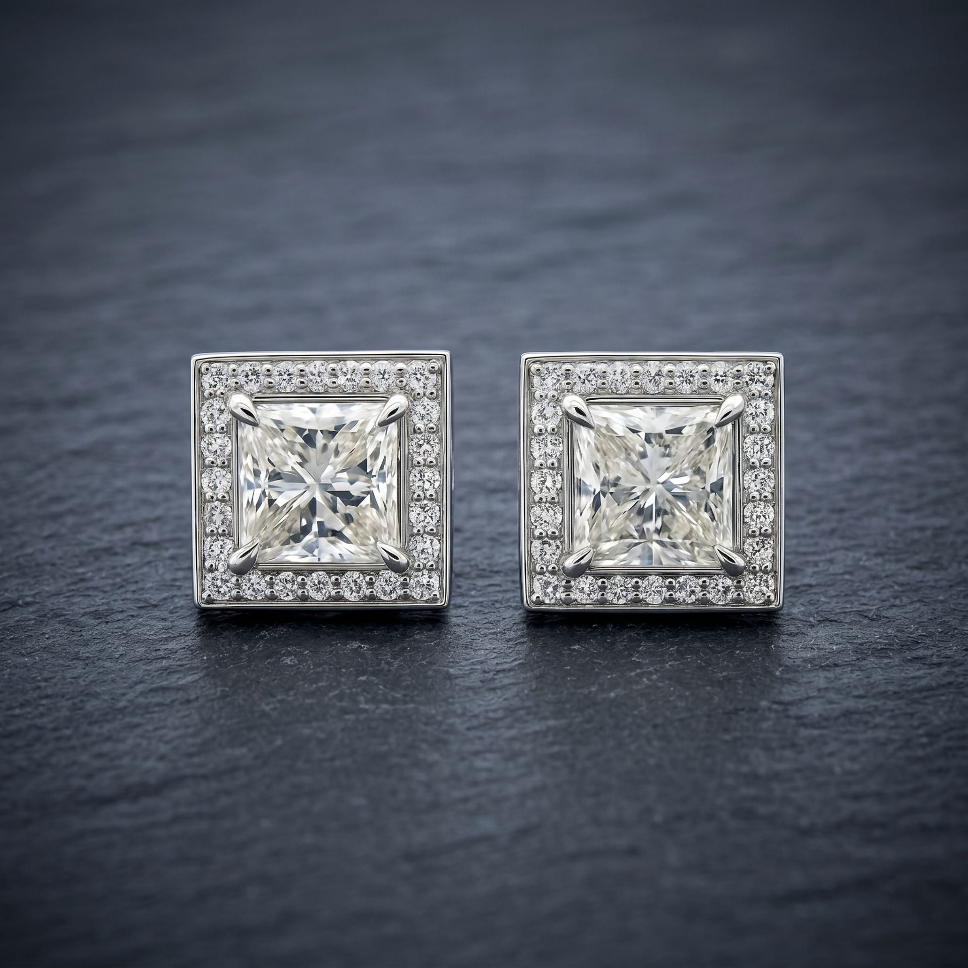Square lab grown diamond stud earrings on a dark textured background