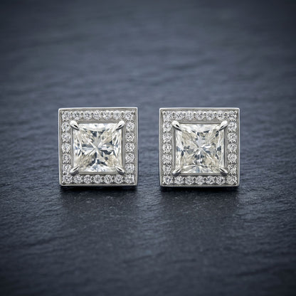 Square lab grown diamond stud earrings on a dark textured background