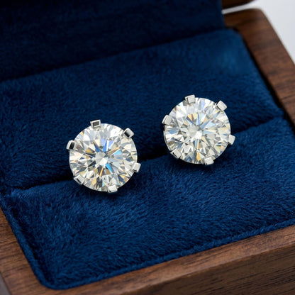 Diamond earrings on a blue cushion with a wooden base