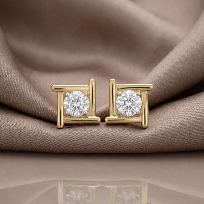 Gold halo lab grown diamond stud earrings on a beige satin background