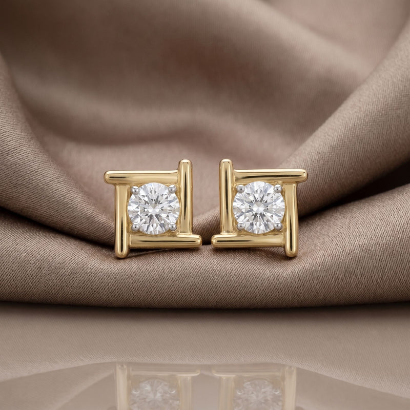 Gold halo lab grown diamond stud earrings on a beige satin background