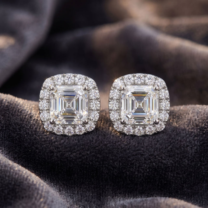Pair of diamond earrings on a dark fabric background