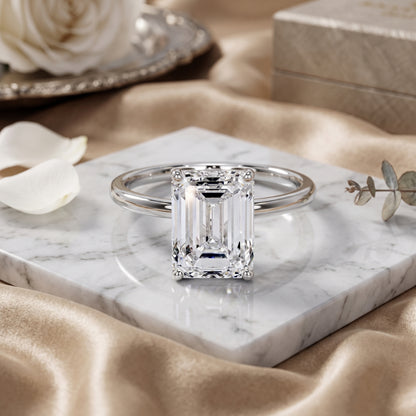 Diamond ring on a marble surface with flowers and jewelry box in the background