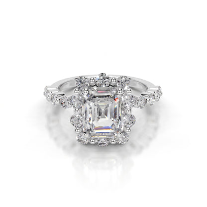 Diamond ring with a central emerald-cut gemstone on a white background