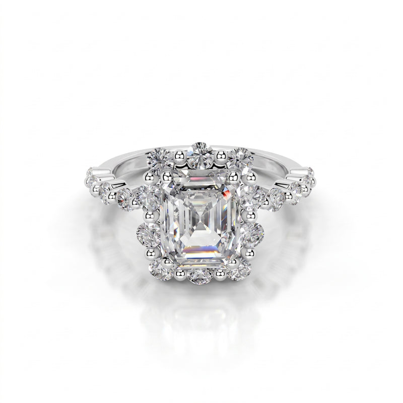 Diamond ring with a central emerald-cut gemstone on a white background