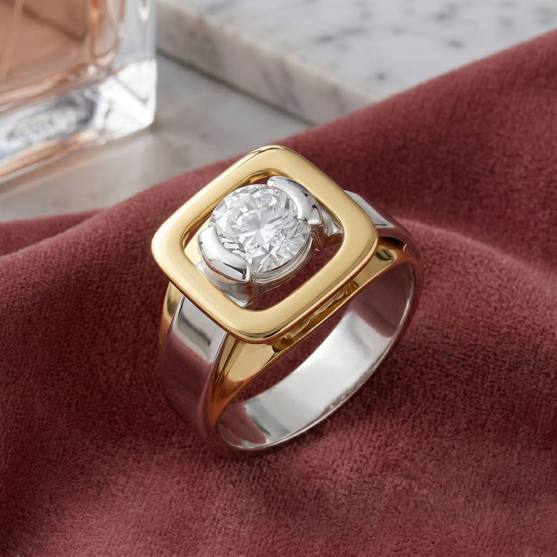 Gold and silver ring with a diamond on a red fabric background
