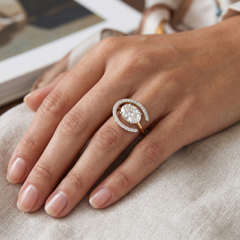 Close-up of a hand wearing a diamond ring on a neutral background