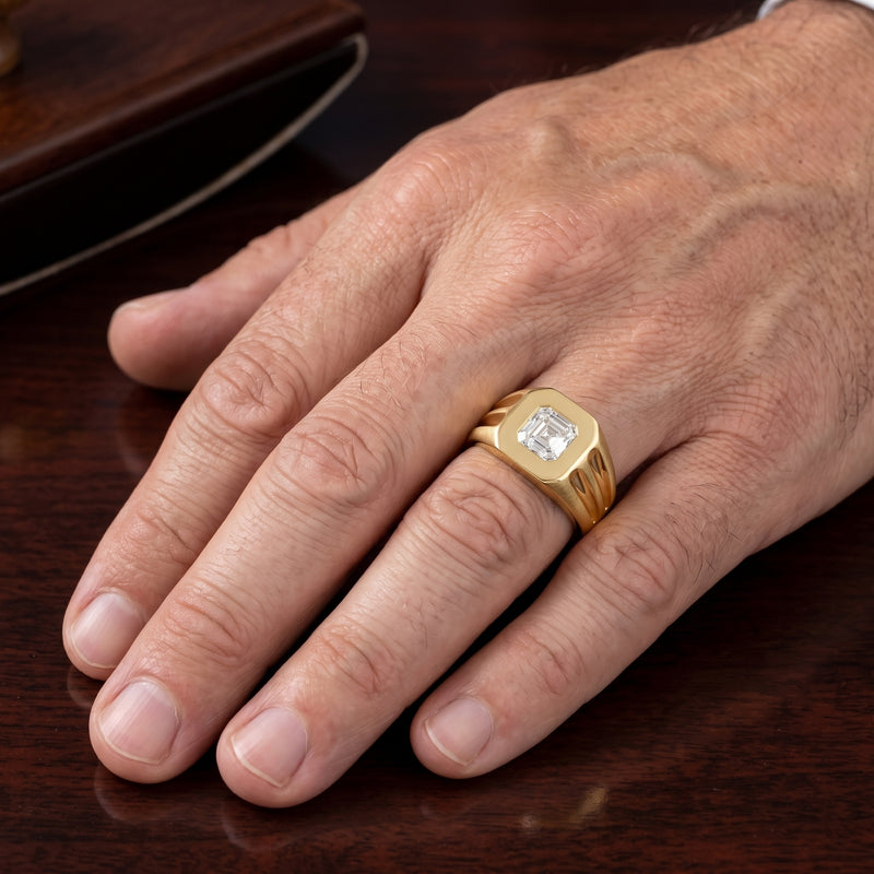 Hand wearing a gold ring with a diamond on a wooden surface