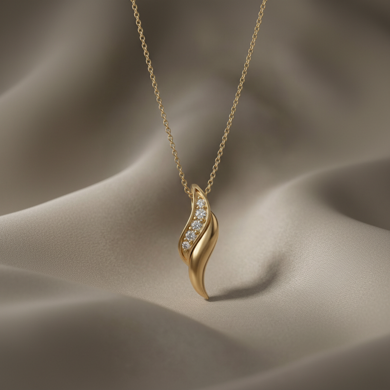 Gold necklace with a wave-shaped pendant on a beige fabric background
