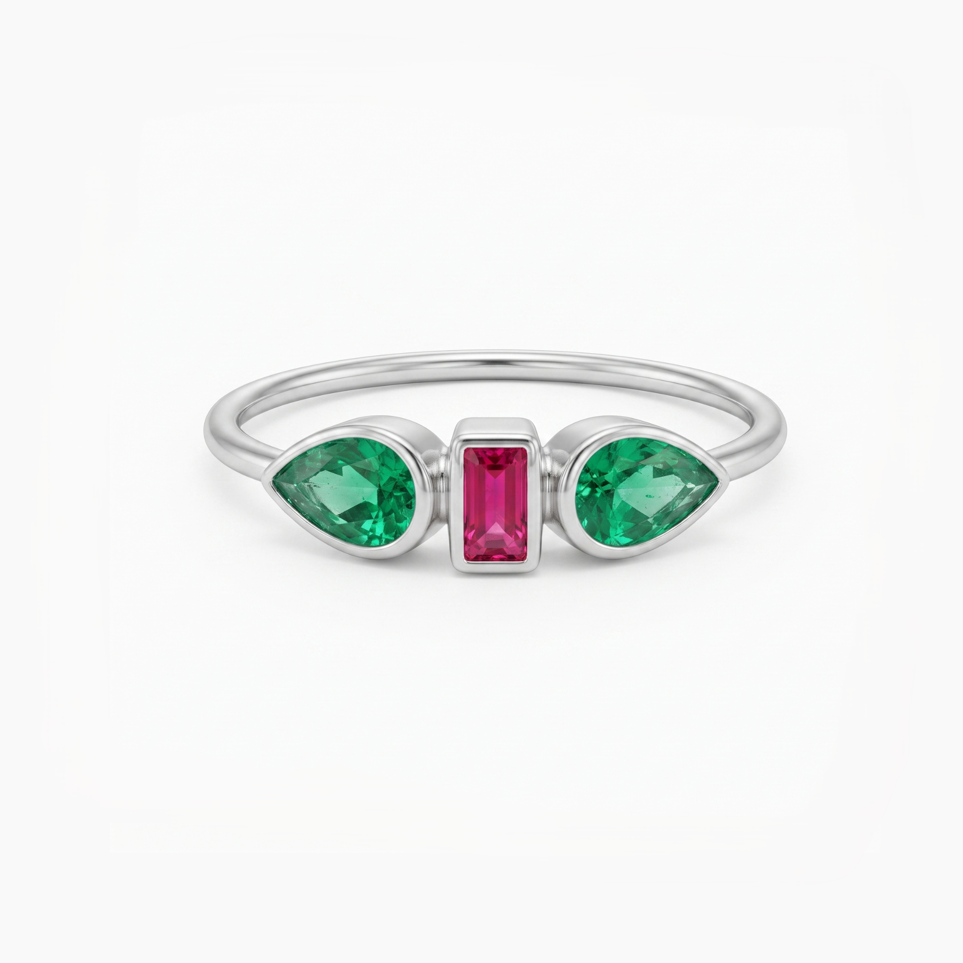A silver ring featuring two green marquise-cut gemstones on either side of a central rectangular pink gemstone, set against a plain white background.