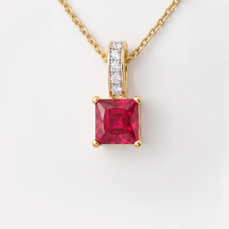 A yellow gold pendant necklace featuring a square-cut red gemstone in a four-prong setting, with a pavé diamond accent on the bail and a matching gold chain, shown against a plain white background.