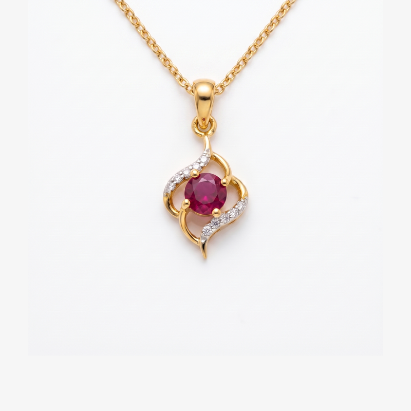 A gold pendant necklace featuring a central round ruby red gemstone surrounded by curved gold and diamond accents, suspended from a gold chain against a plain white background.
