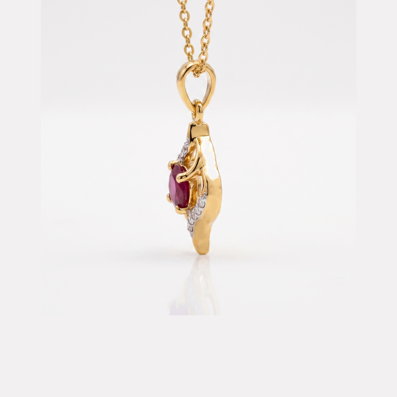 A gold pendant necklace featuring a sculpted shoe design with a central oval ruby gemstone and a row of small clear accent stones, suspended from a gold chain against a white background.