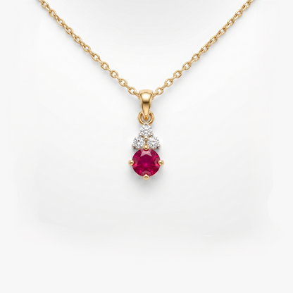 A gold pendant necklace featuring a round-cut pinkish-red ruby gemstone and a small cluster of clear stones above it, shown on a white background.