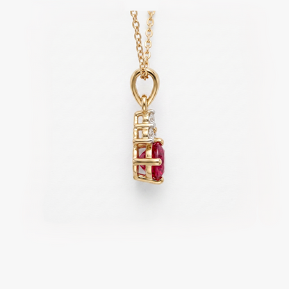 A gold pendant necklace featuring a vertical setting with a prominent oval-cut red ruby center stone and a small clear diamond beside it, suspended from a delicate gold chain against a clean white background.