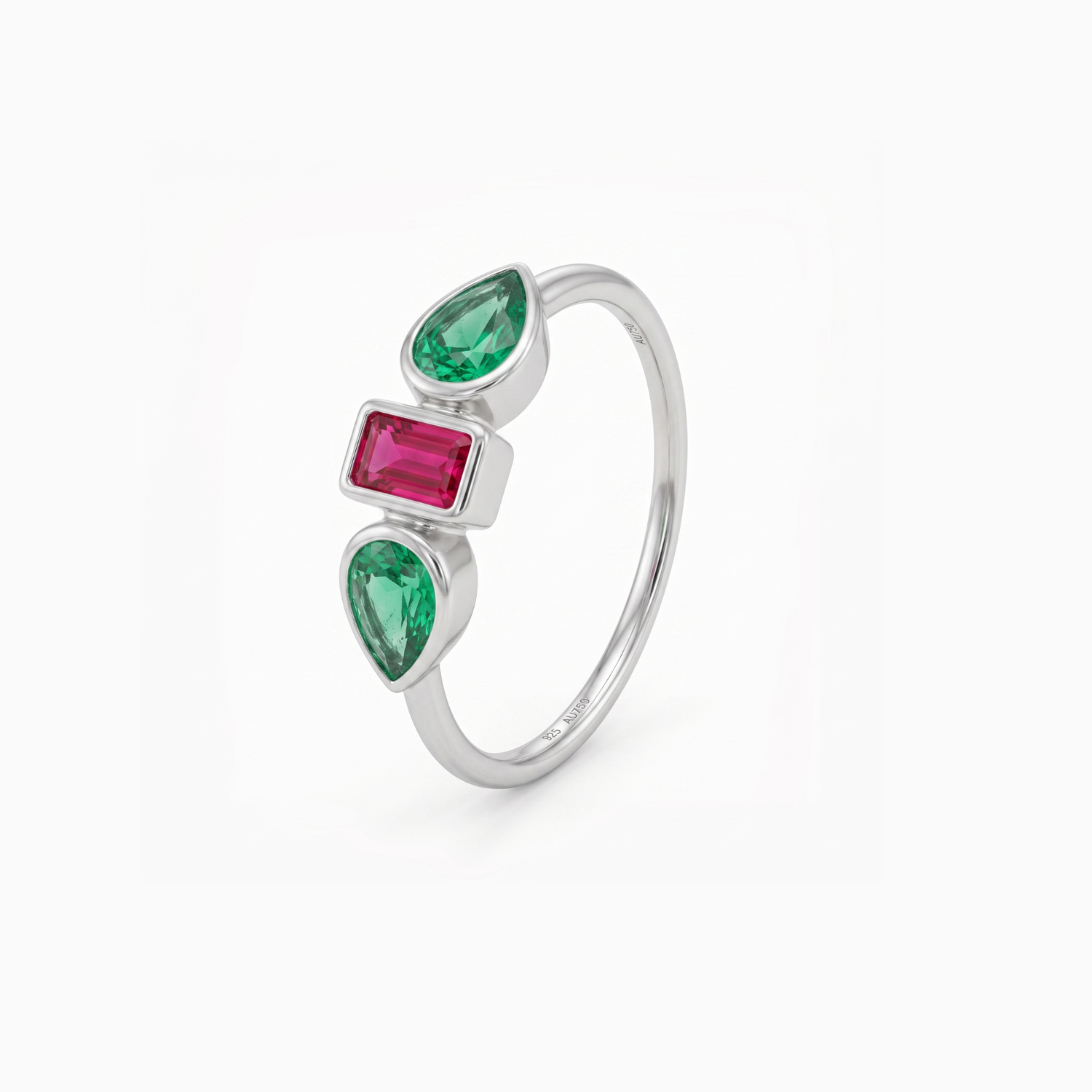 A silver ring featuring three vertically aligned gemstones: two pear-cut emerald-cut green stones and one rectangular emerald-cut pink stone, set in a polished silver band against a clean white background.