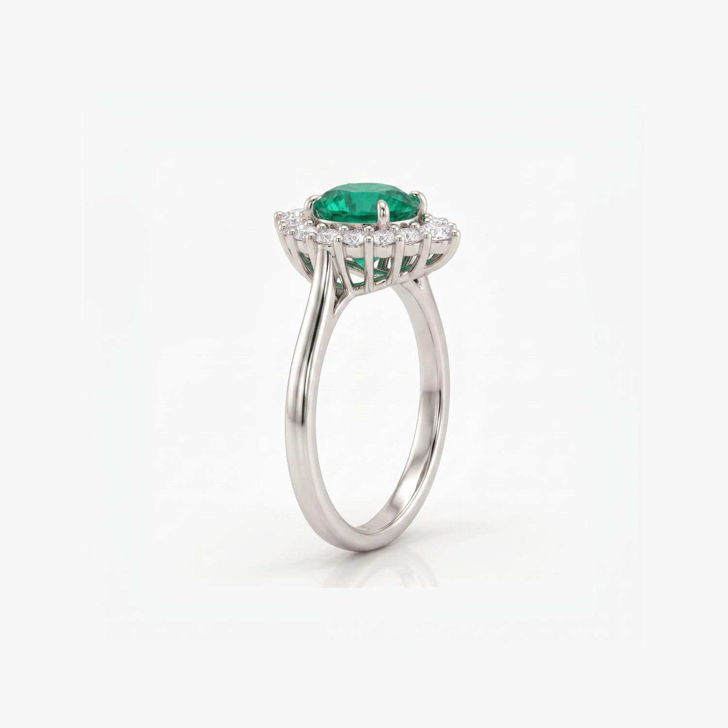 A silver-toned halo ring featuring a round green emerald-cut center stone and a surrounding halo of small clear stones, shown on a clean white background.