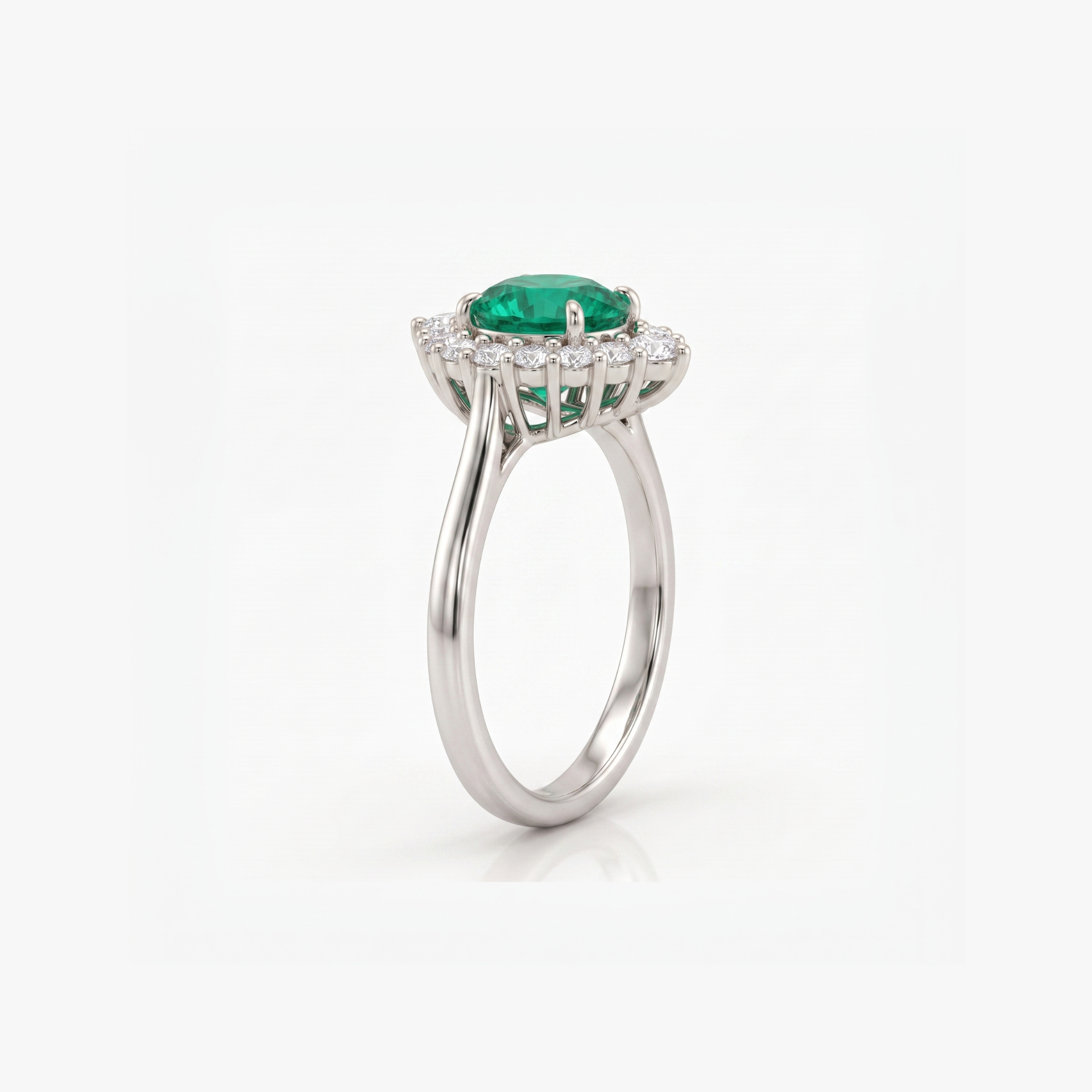 A silver-toned halo ring featuring a round green emerald-cut center stone and a surrounding halo of small clear stones, shown on a clean white background.