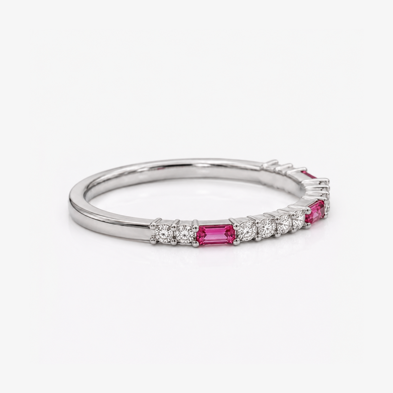 A silver band ring featuring a row of baguette-cut pink gemstones and small round clear stones, photographed on a clean white background.