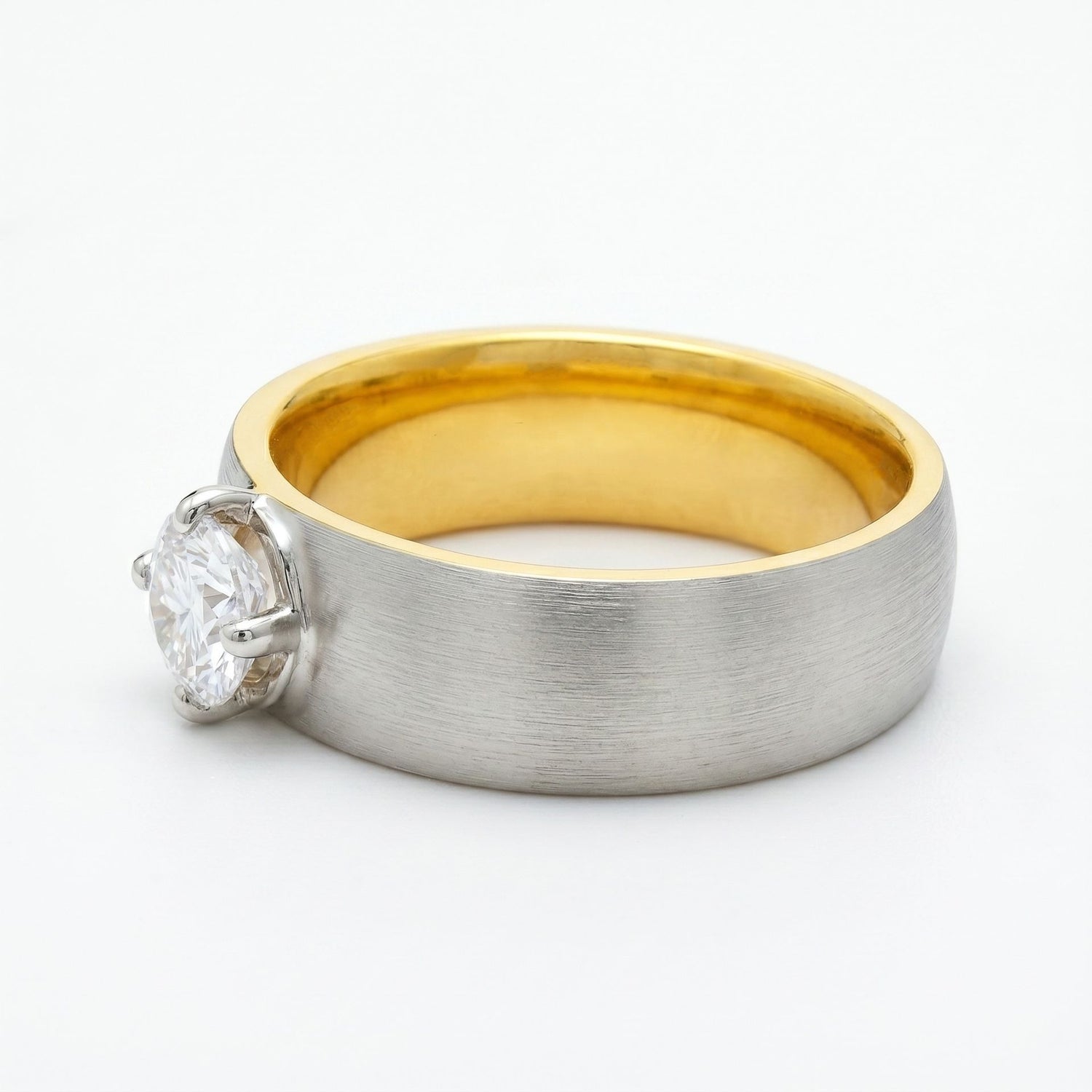 Two-tone gold and silver ring with a diamond on a white background