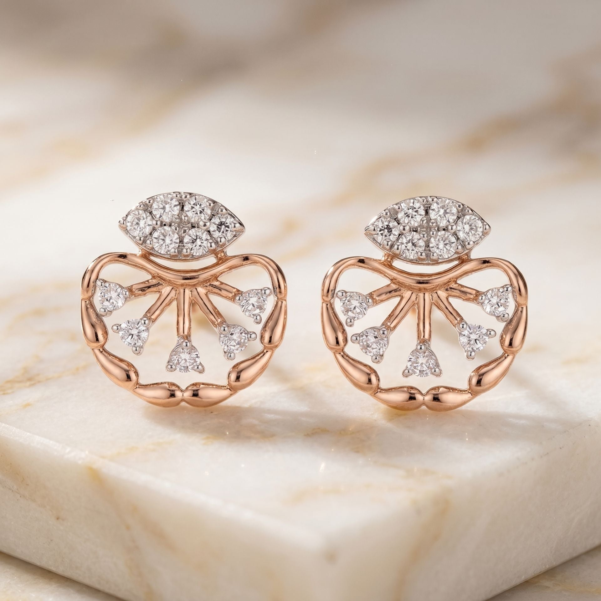 Rose gold floral lab grown diamond stud earrings on a marble display