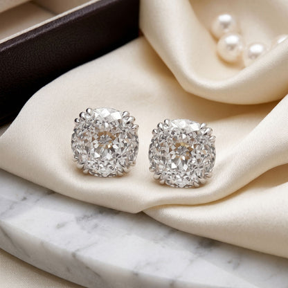 Square lab-grown diamond stud earrings on a beige velvet cushion