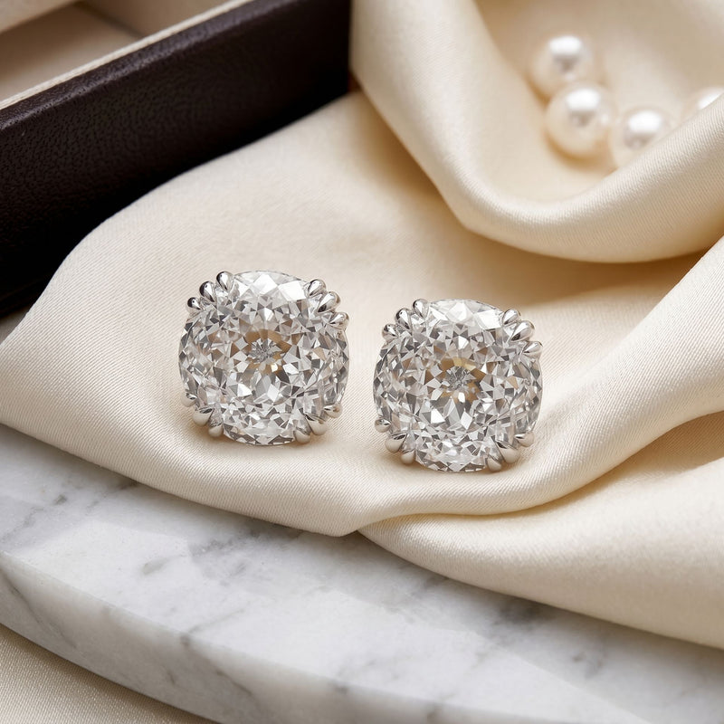Square lab-grown diamond stud earrings on a beige velvet cushion