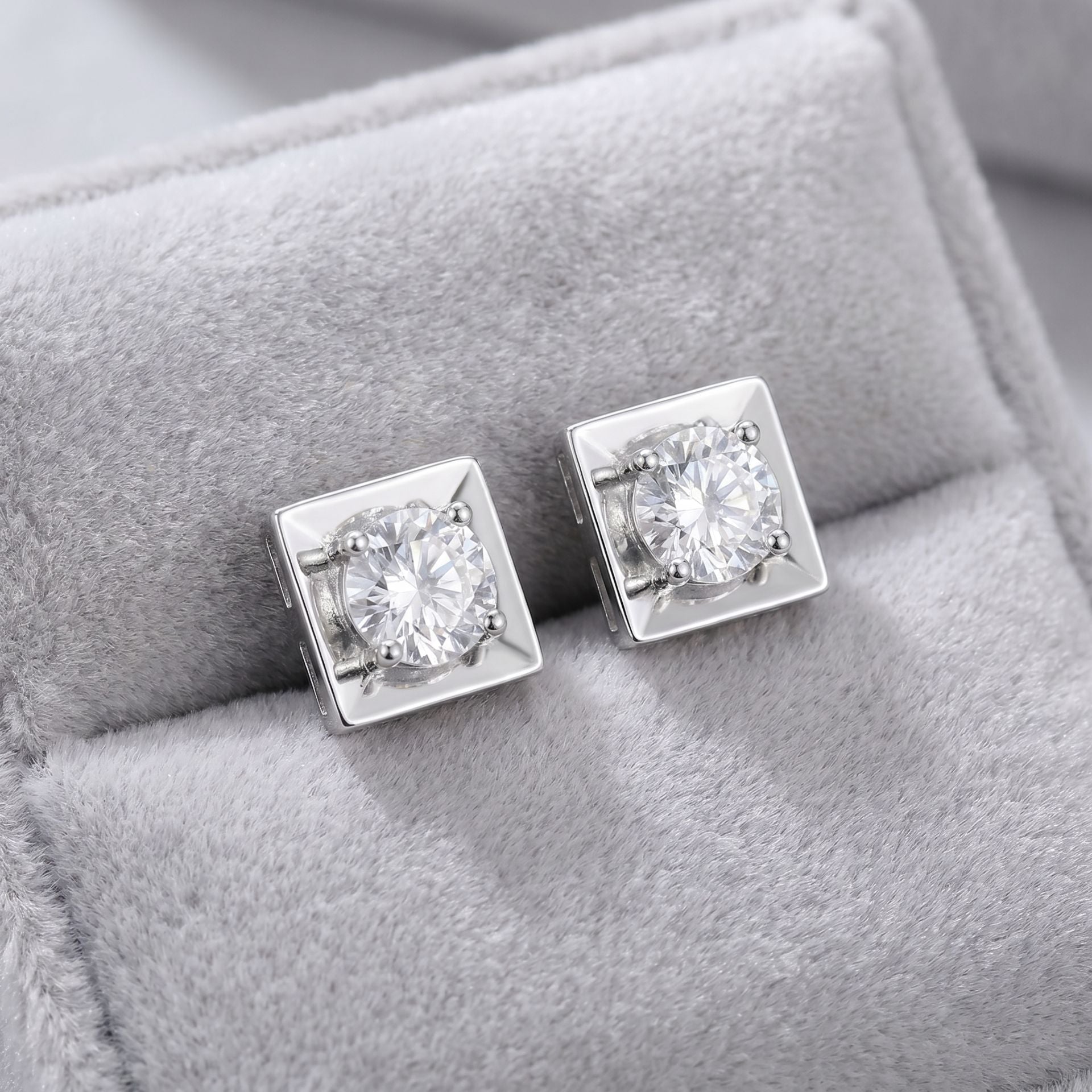 Square lab grown diamond stud earrings on a grey velvet cushion