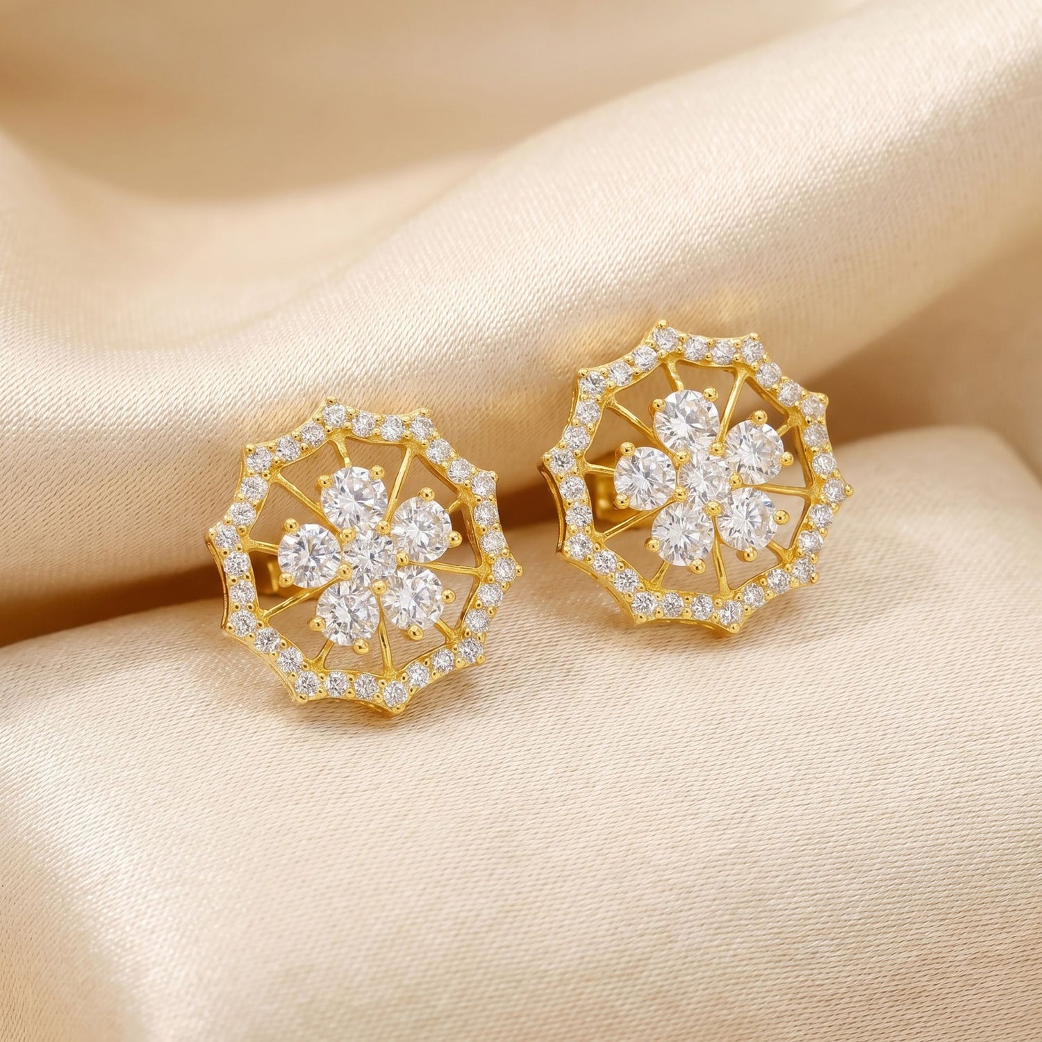Gold floral lab grown diamond stud earrings on a beige fabric background