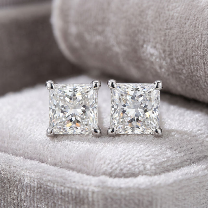 Square lab grown diamond stud earrings on a grey velvet cushion