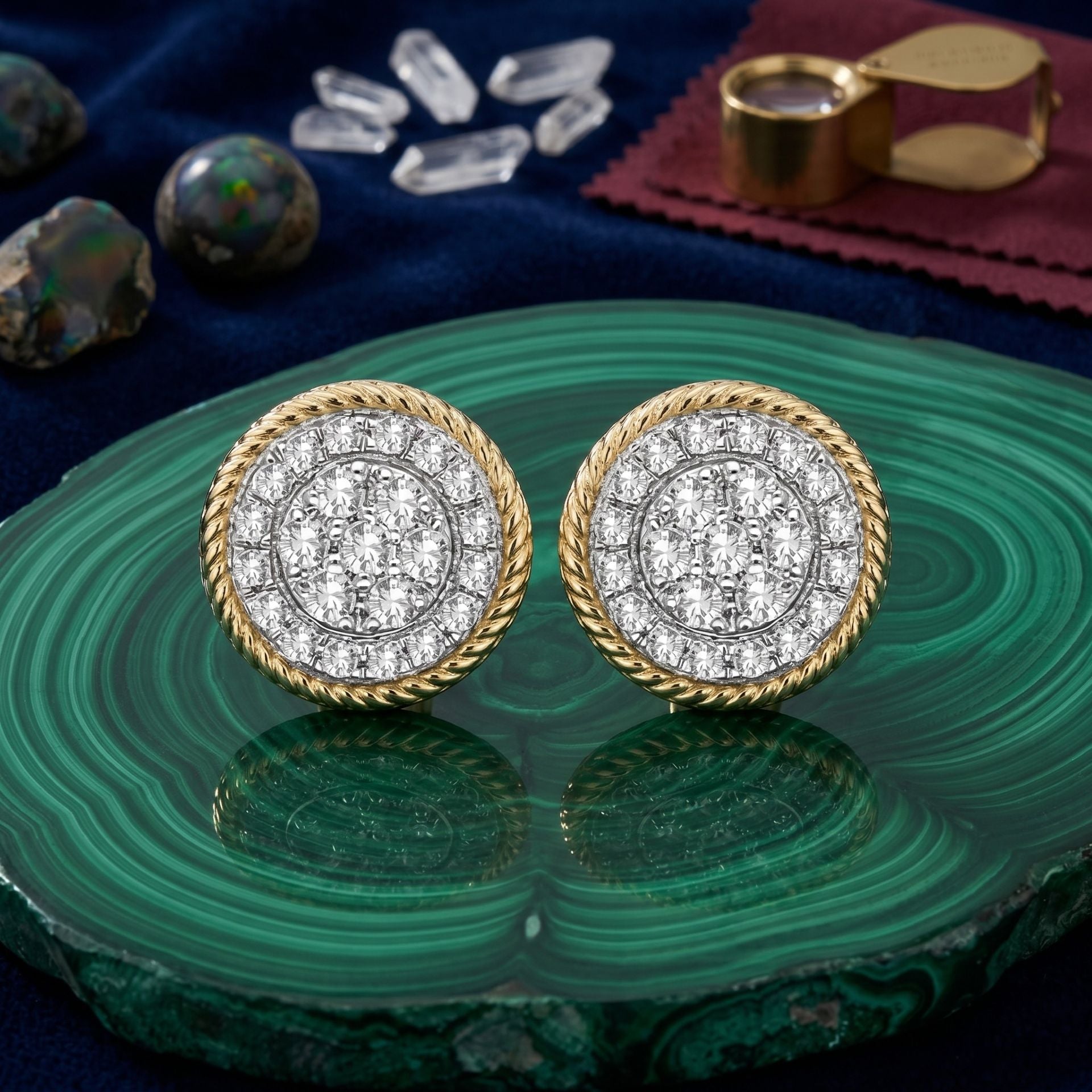 Gold and diamond earrings on a green stone surface with opals and a magnifying glass in the background.