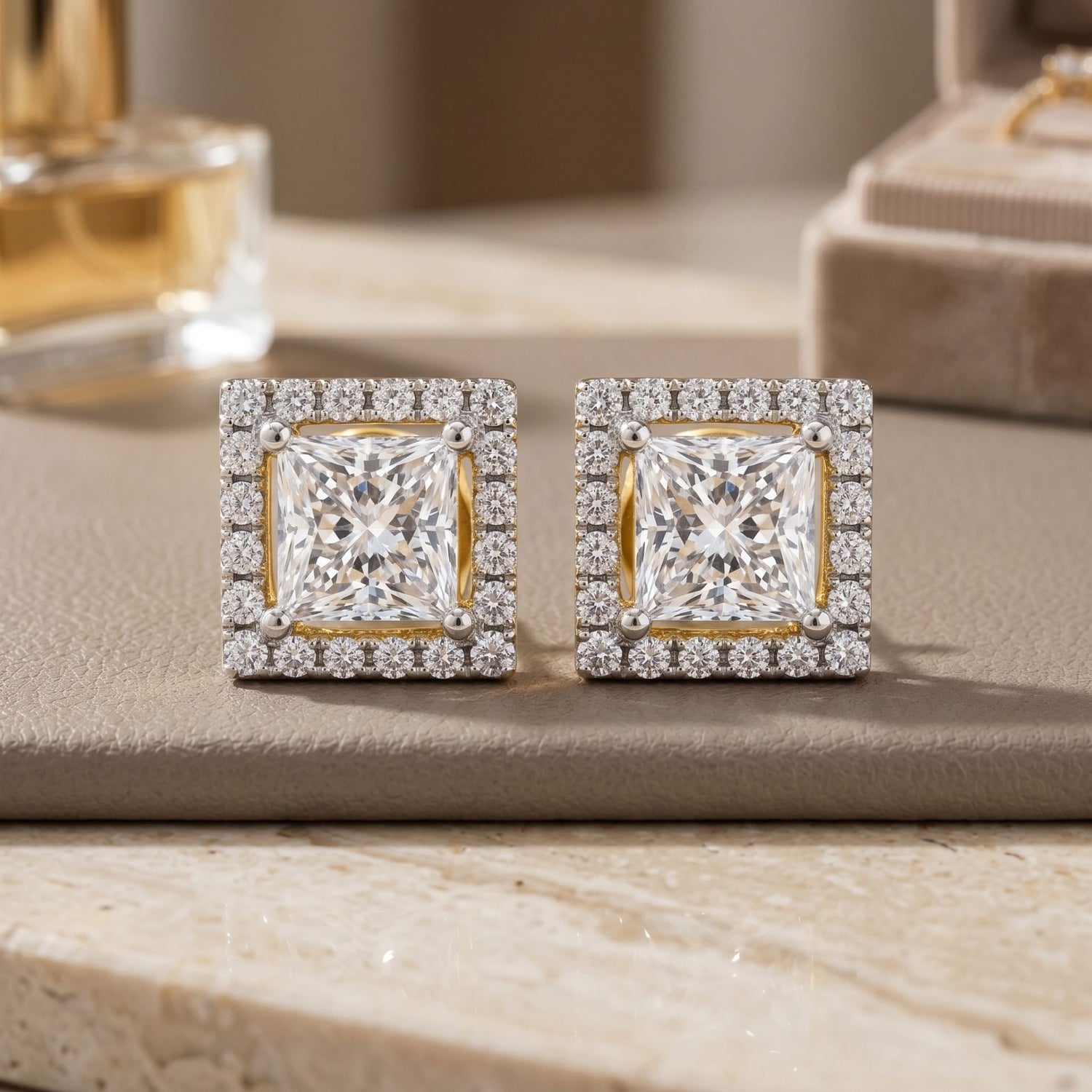 Pair of diamond earrings on a beige surface with a blurred background
