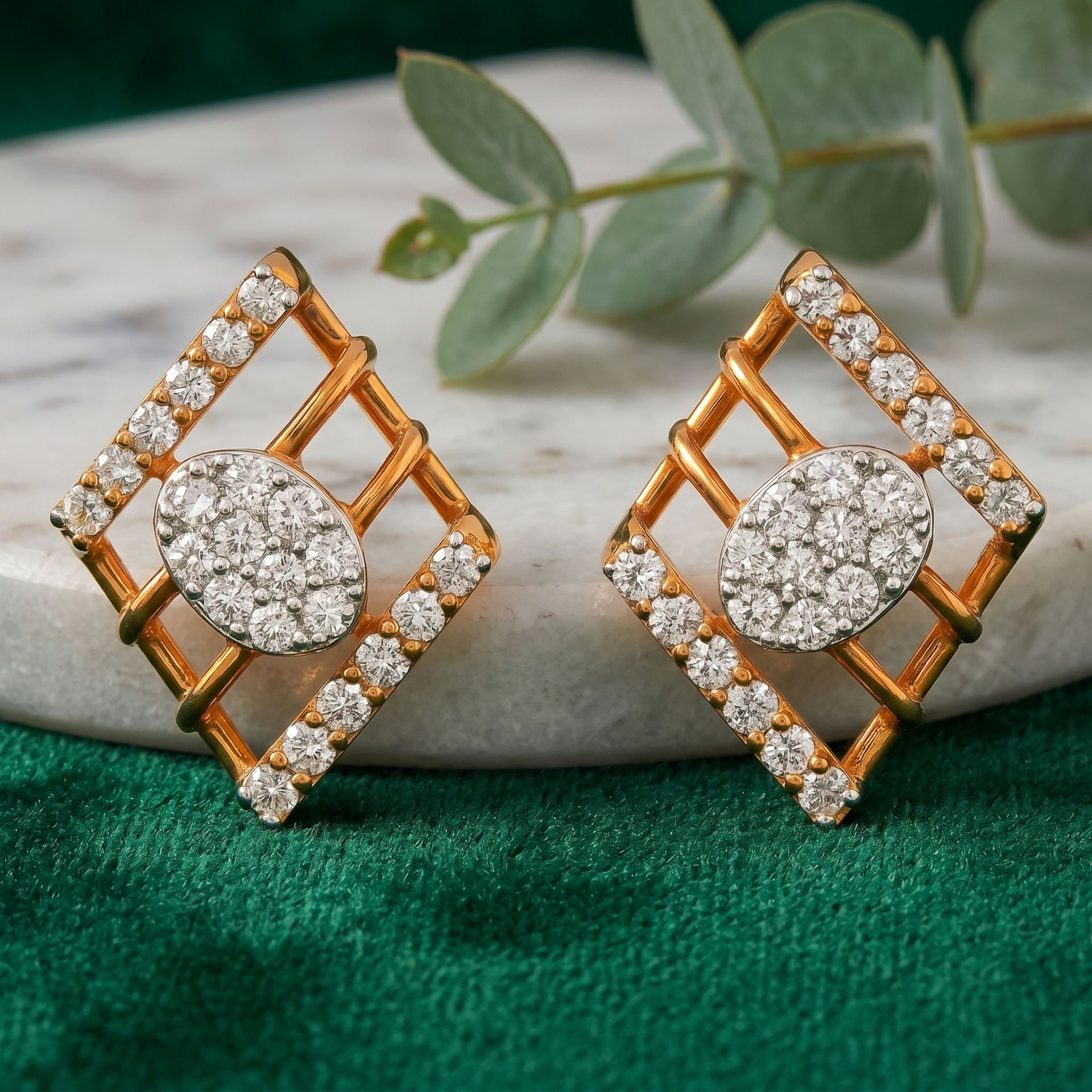 Geometric gold stud earrings featuring round clusters of sparkling lab-grown diamonds with diamond-accented square frames on a green velvet background.
