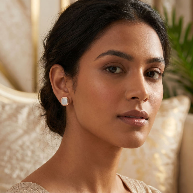 Woman wearing diamond earrings with a neutral background