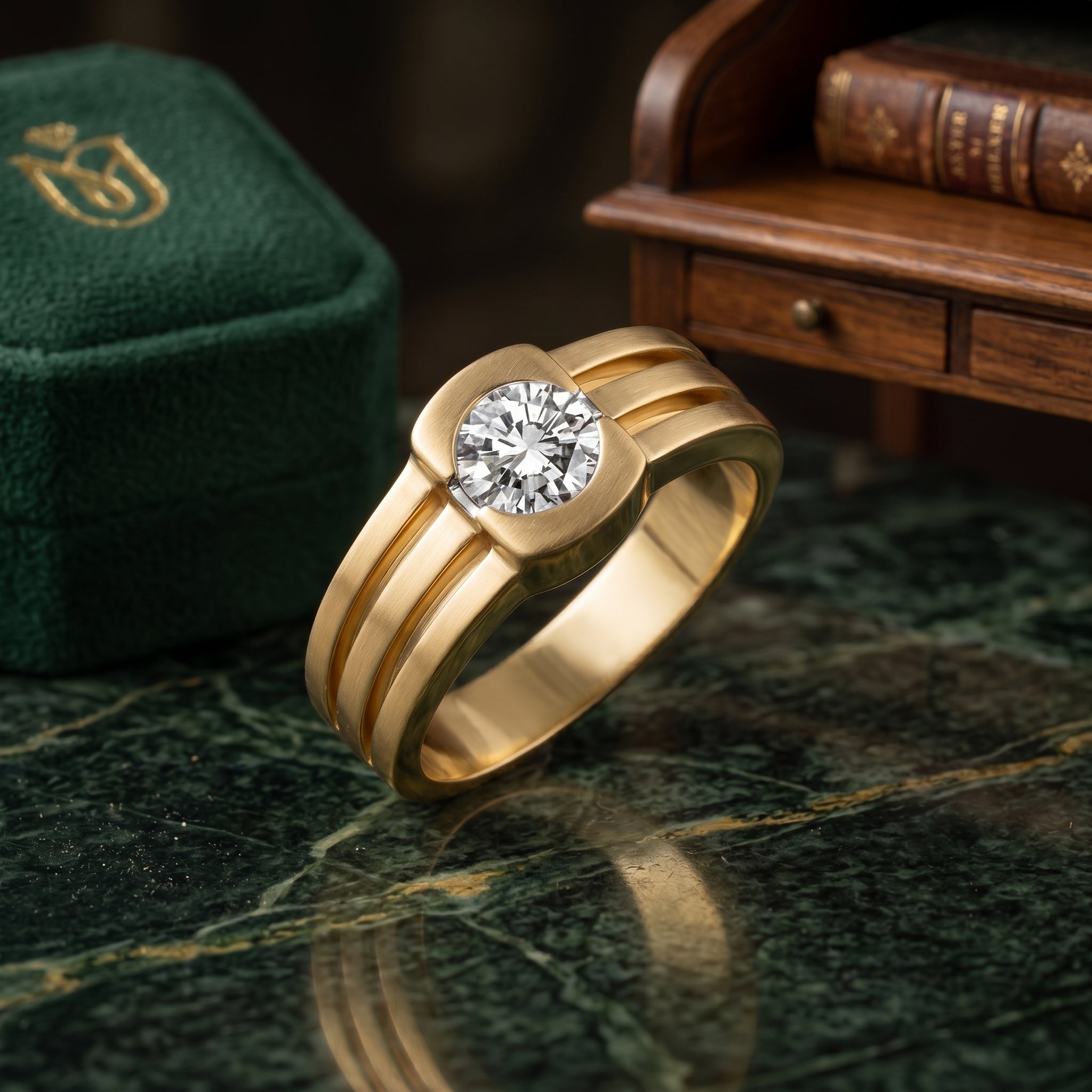 Gold ring with a diamond on a green marble surface with a green box and wooden books in the background.