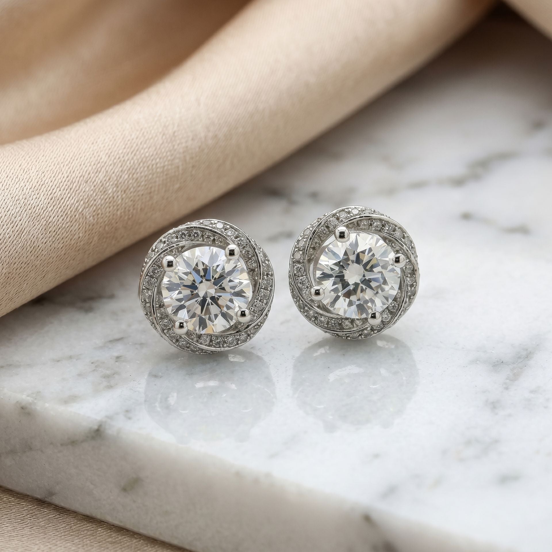 Pair of diamond stud earrings on a marble surface